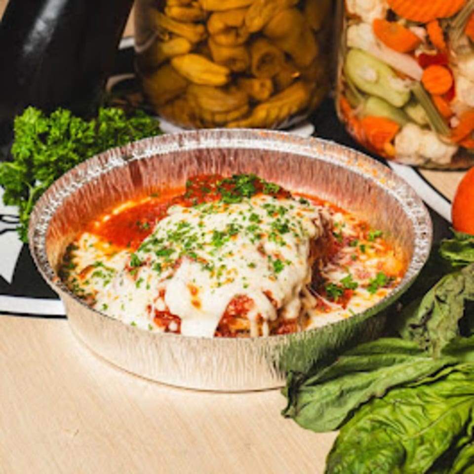 Stallone's Italian Eatery's baked ziti with melted cheese and red sauce in a foil container.