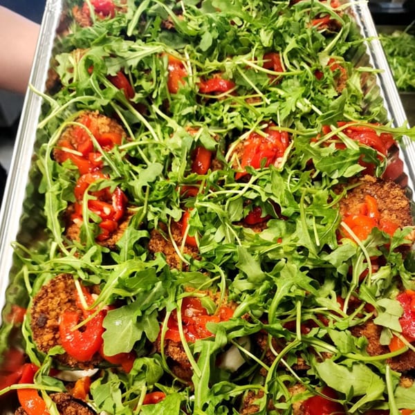 Close-up of Stallone's Italian Eatery's fried eggplant with red peppers and fresh arugula.